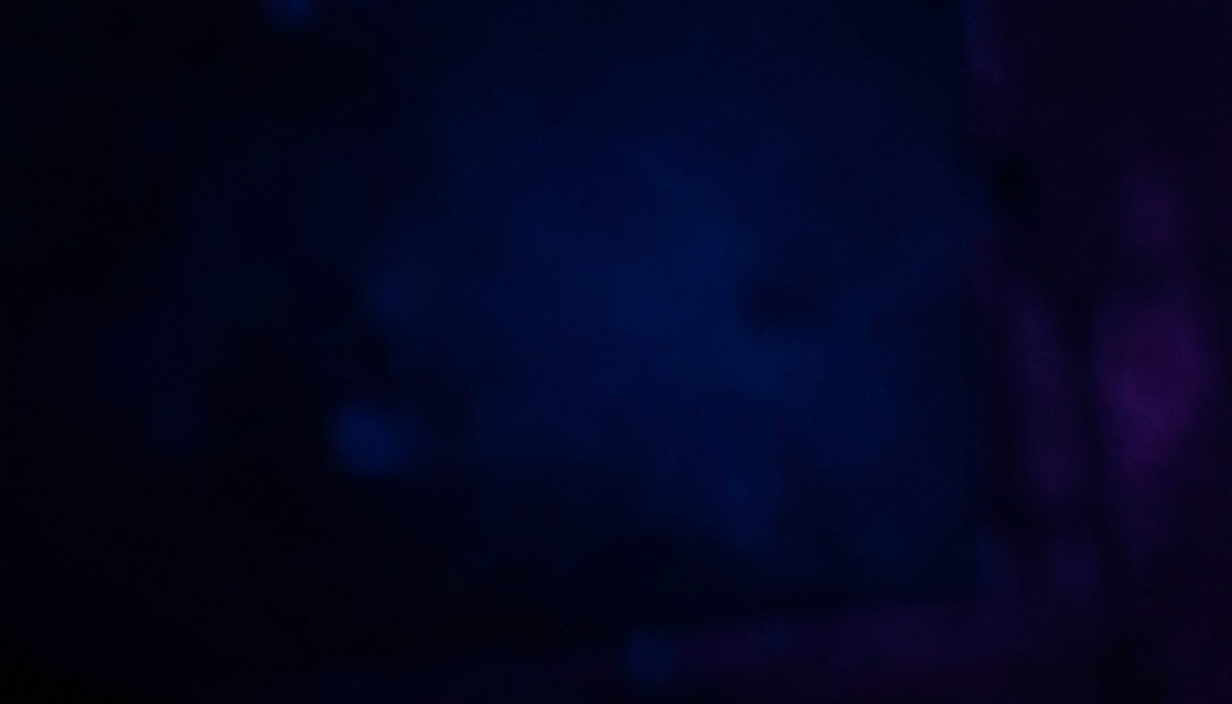 Deep blue and violet moody frame from a music teaser clip with cinematic shadows