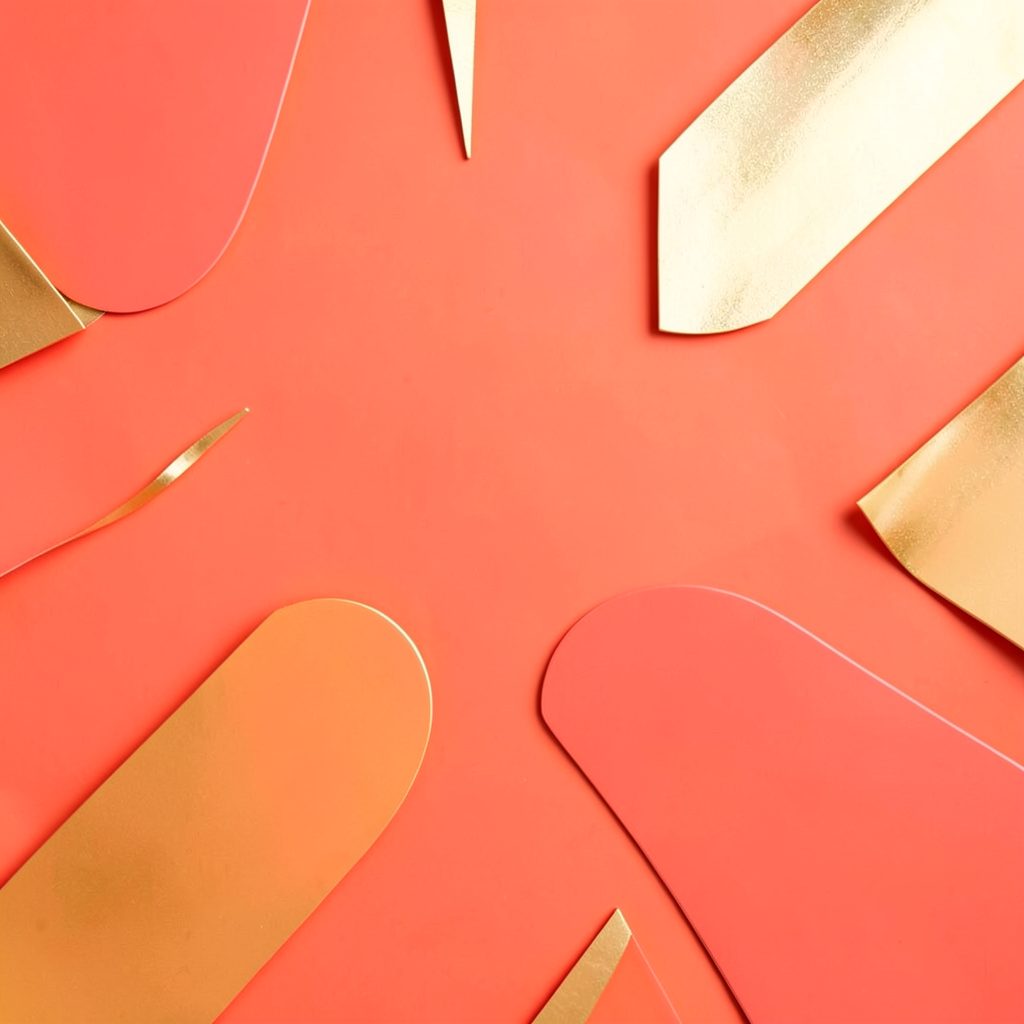 Vibrant coral and gold abstract shapes suggesting festive energy